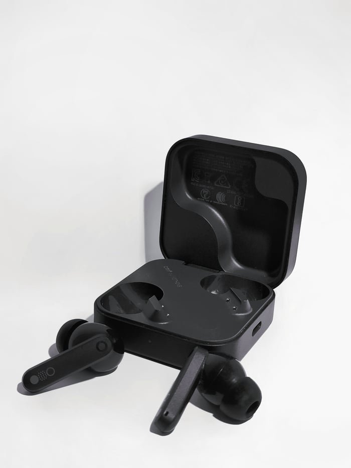 Elegant black wireless earbuds showcased in an open charging case on a white background.